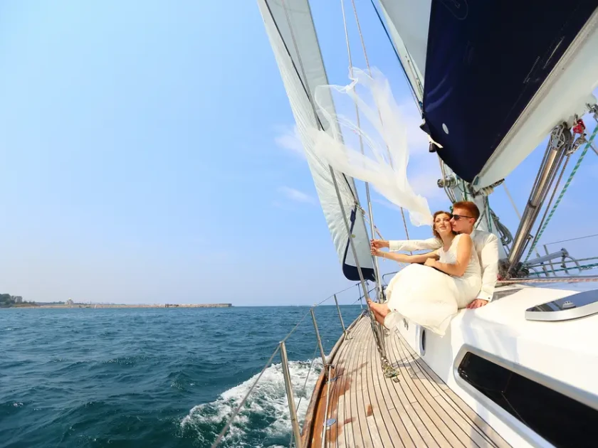 a newlywed couple sitting together on a sailing boat