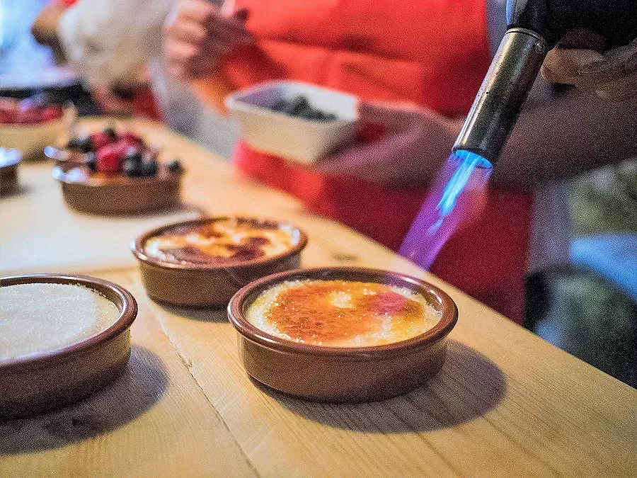 Burning the sugar on a dish of Crema Catalana